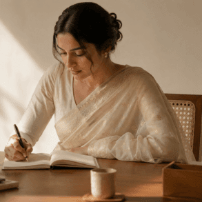 Woman wearing a pale ivory Chanderi cotton-silk saree at an office desk