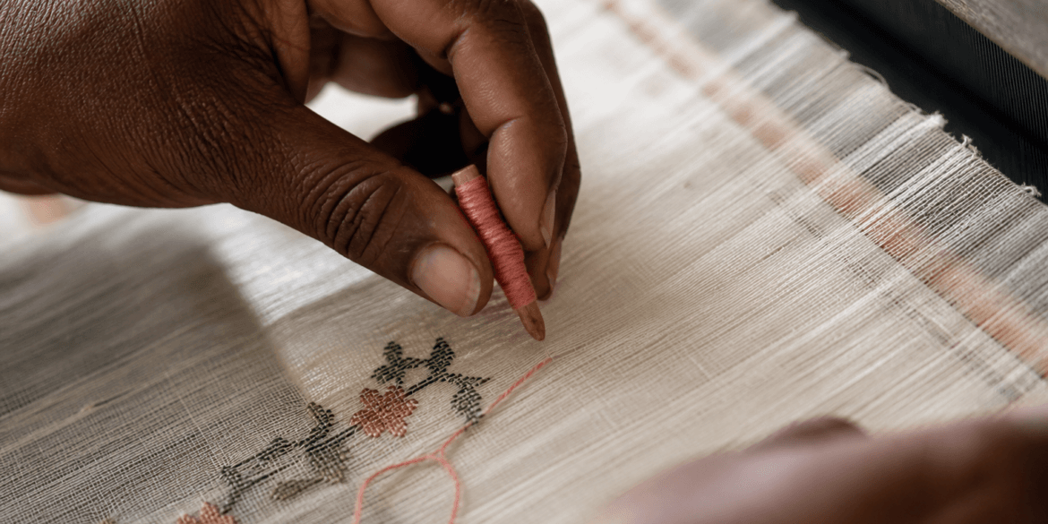 Weaver's hands placing discontinuous weft thread on a Jamdani loom