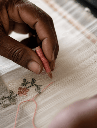 Weaver's hands placing discontinuous weft thread on a Jamdani loom