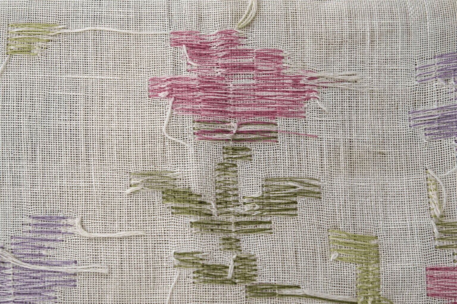 Macro detail of a Jamdani motif on the loom showing floating weft threads
