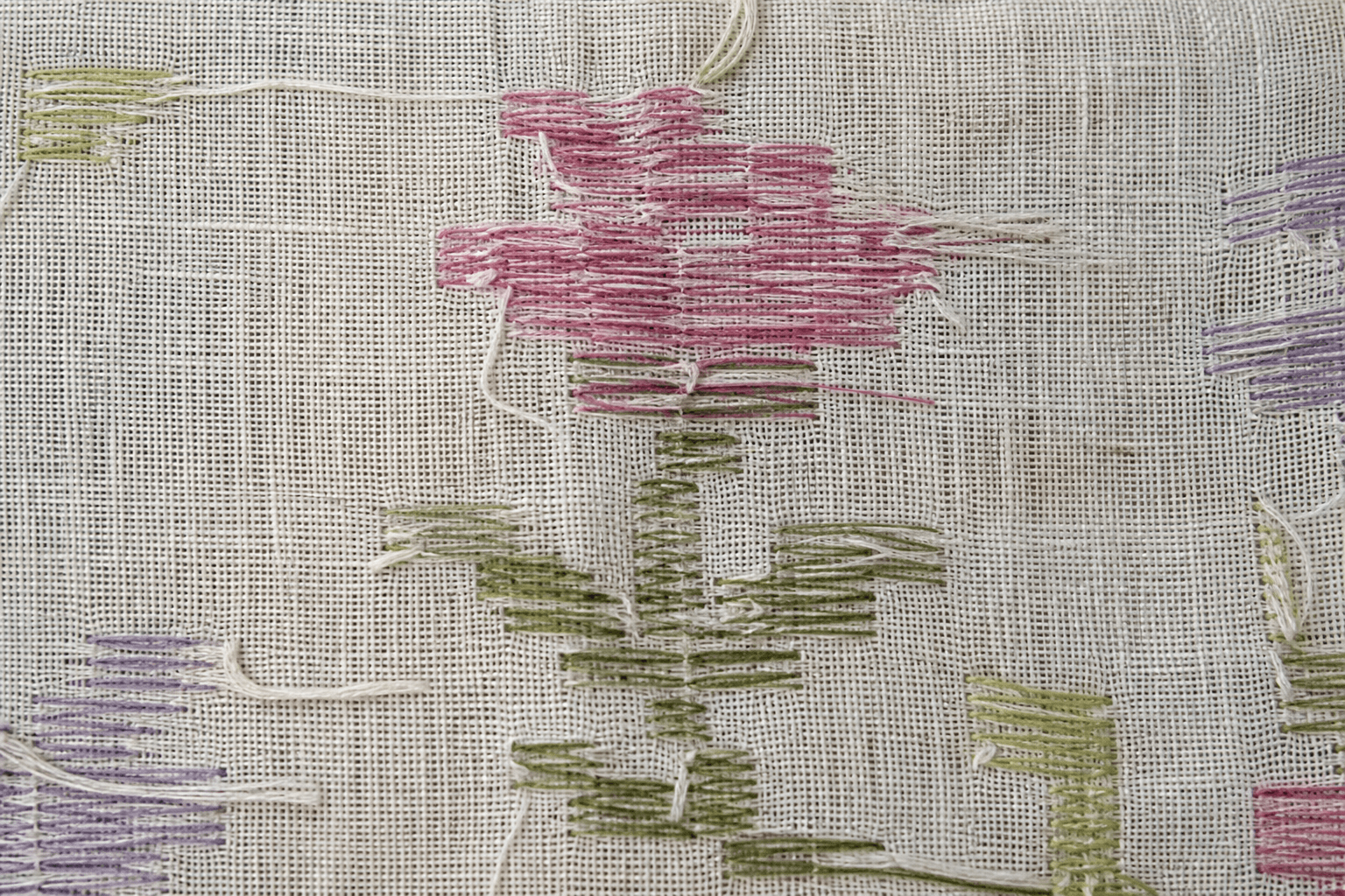 Macro detail of a Jamdani motif on the loom showing floating weft threads