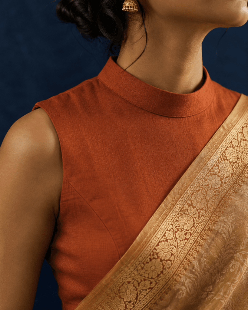 Structured high neck saree blouse paired with a Banarasi gold border