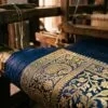 Real zari thread on a Banarasi saree border, tested against Varanasi loom light