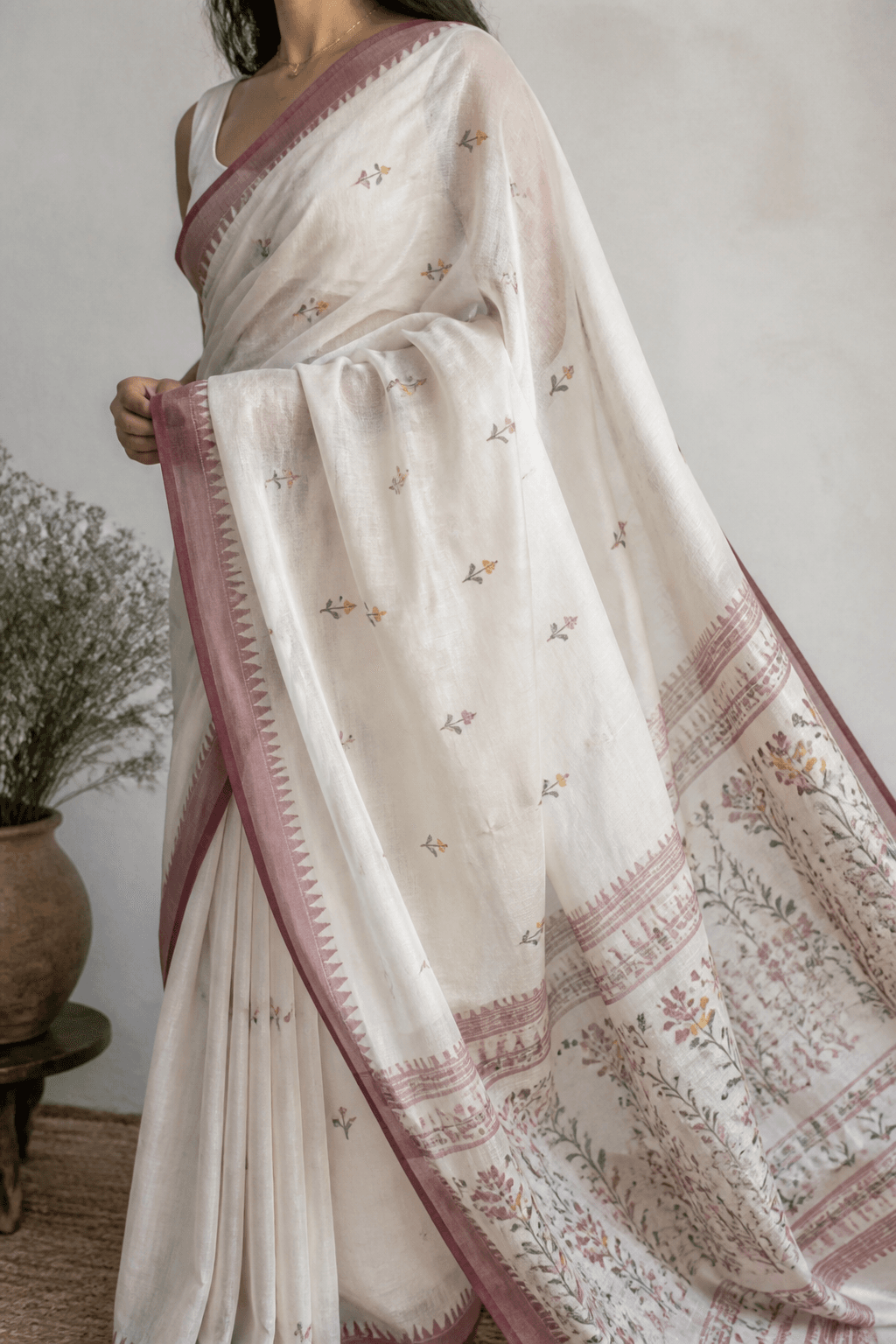 Off-white Jamdani saree draped on a model, showing translucent base and floral border